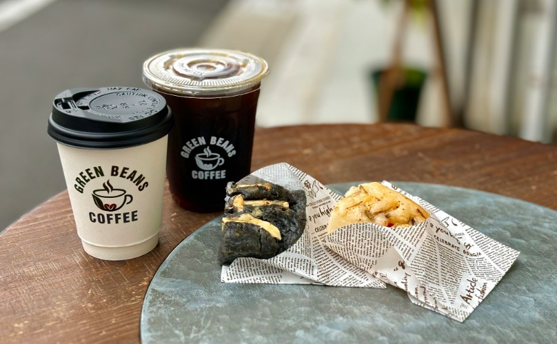 グリーンビーンズコーヒーのカップ2つとグルテンフリーフォカッチャが並んだテーブル
