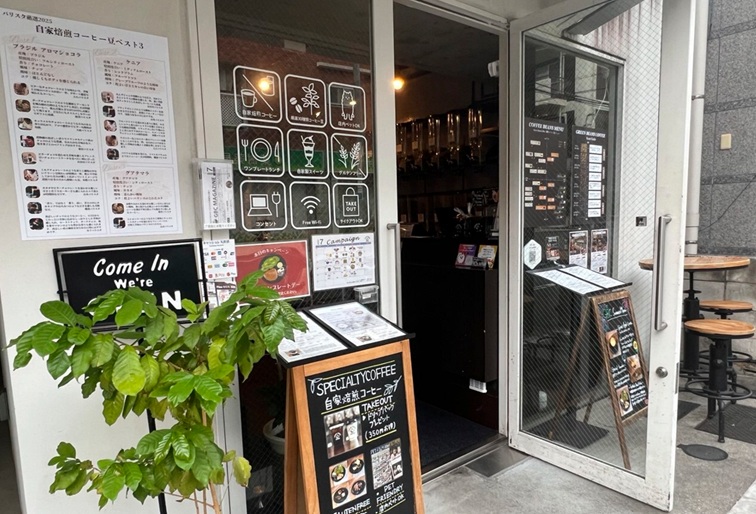 店名看板のないGreen Beans Coffeeの入り口、メニューやウェルカムボードが並ぶ外観