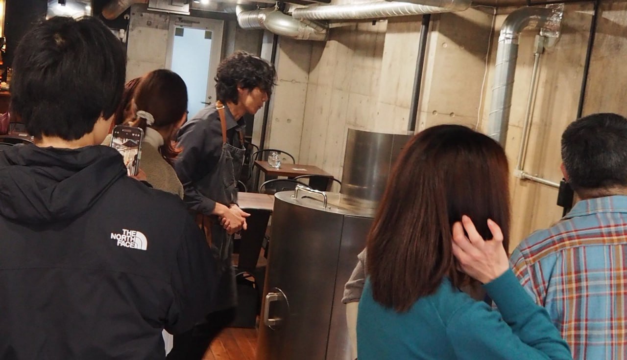 体験イベントに参加する複数のお客さんとスタッフさんが並ぶ店内の様子