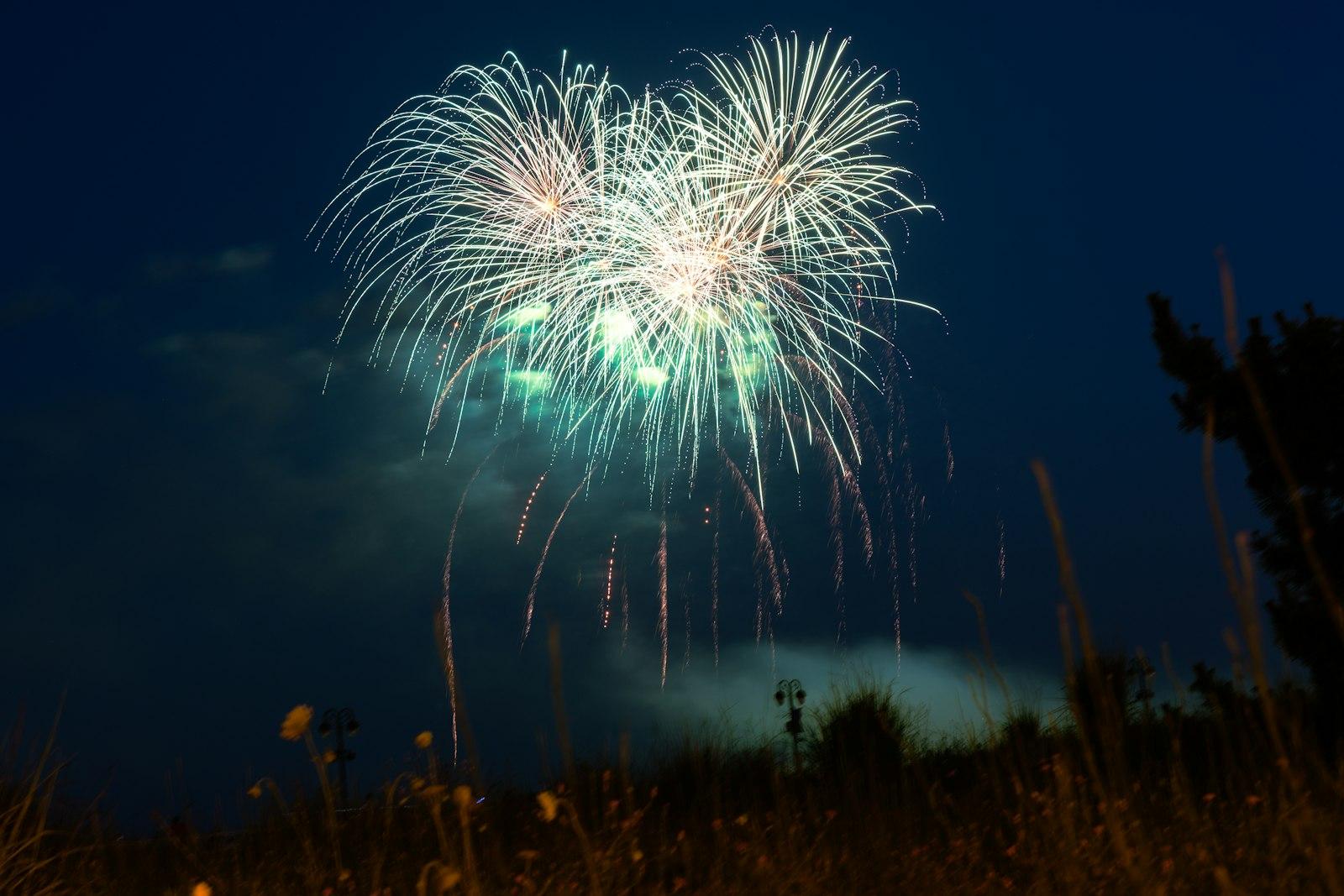 東京の夜空に大きく打ち上がる白と緑の花火、神宮外苑花火大会をイメージした写真
