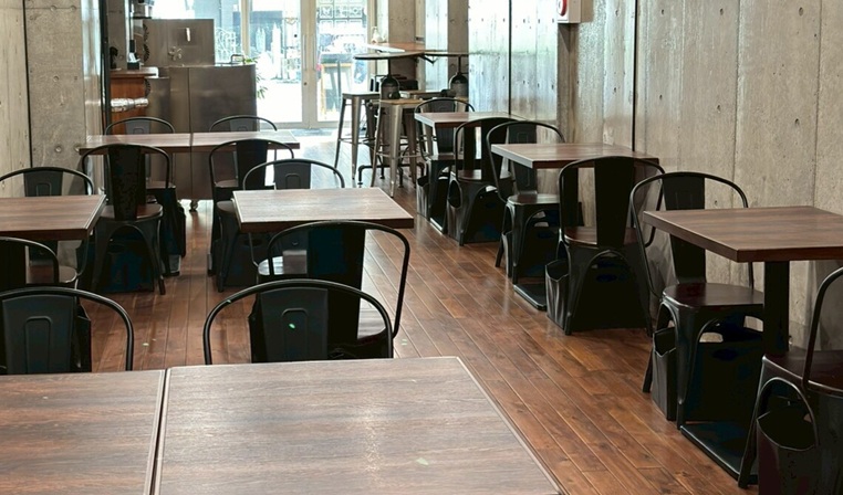開店直後の誰もいない静かな店内、木のテーブルと椅子が並ぶ様子