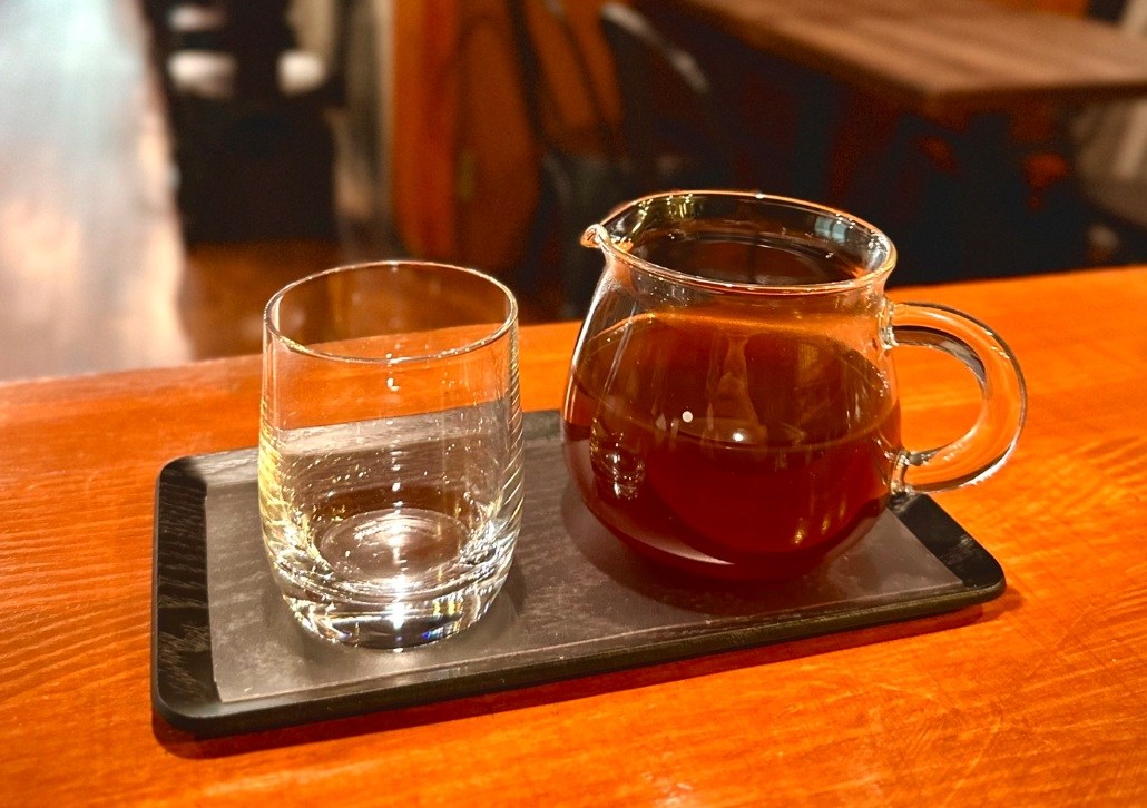 ガラスサーバーに抽出されたハンドドリップコーヒーと、隣に添えられたお冷のグラス